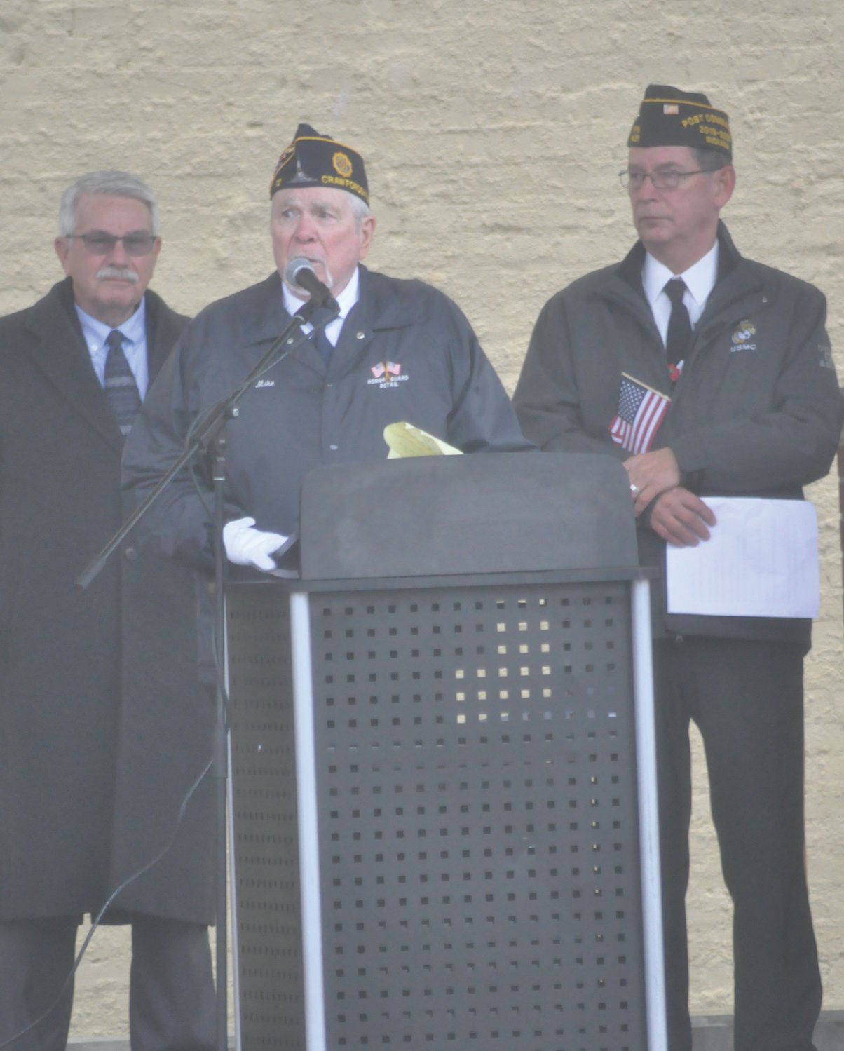Post 72 third vice commander Mike Spencer, center, delivers remarks as Mike Whitacre and Brian Bowman VFW Post 1431 commander Marc Gabel listen Monday during the community Veterans Day ceremony at Pike Place.